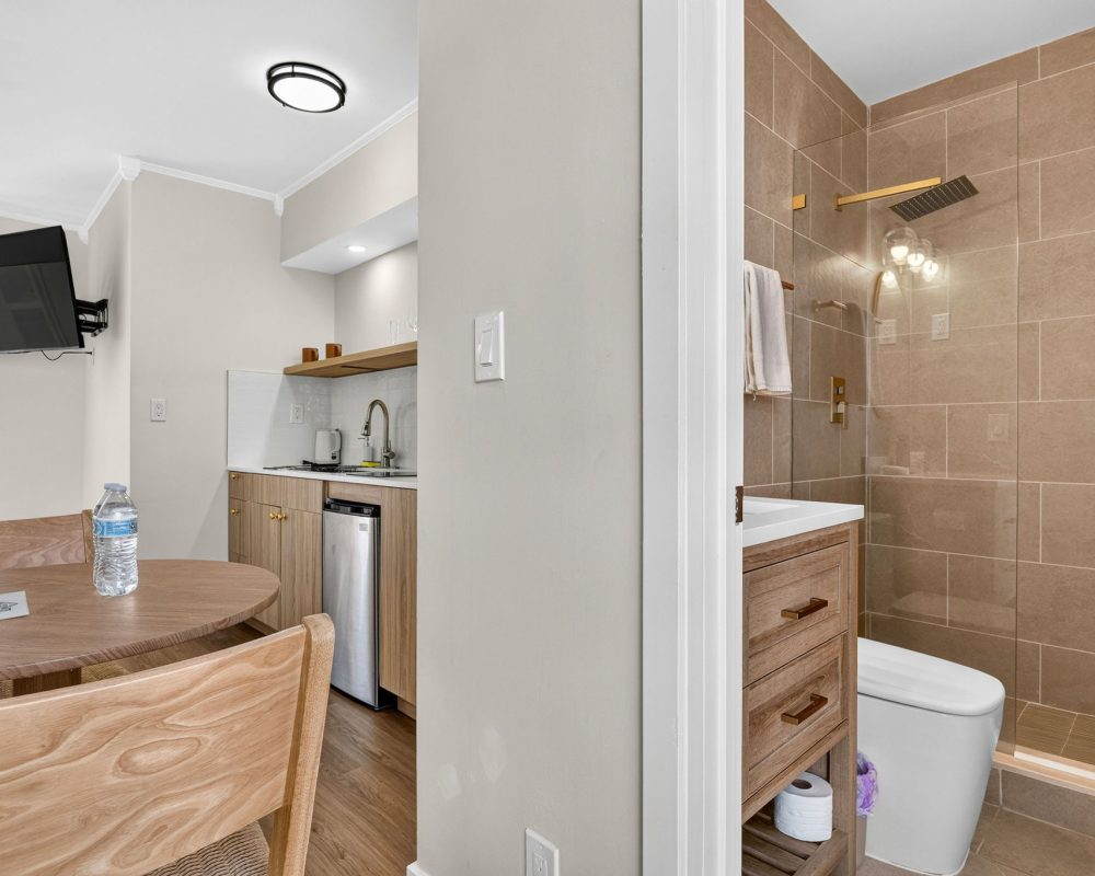Bathroom and kitchenette area in the Deluxe Quadruple Room at Tiana Beach Inn