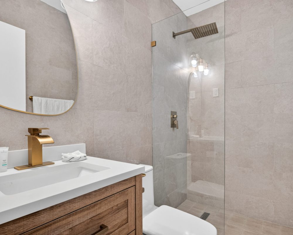 Private bathroom with vanity and walk-in shower at Tiana Beach Inn