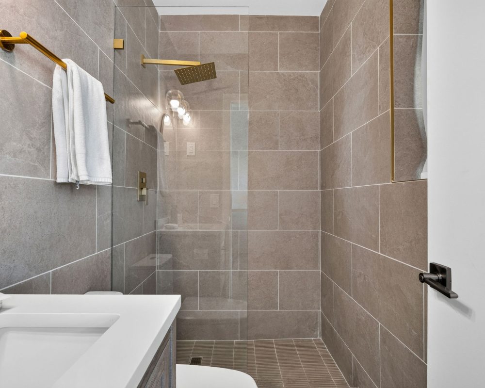 Modern walk-in shower in a Standard Queen Studio bathroom at Tiana Beach Inn