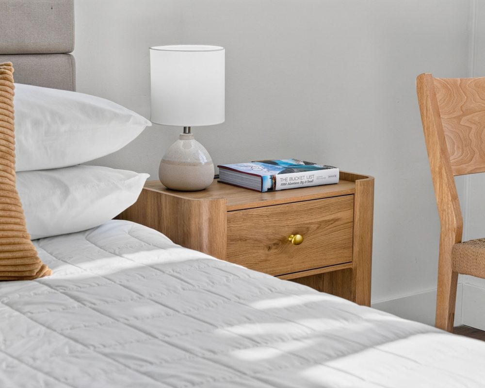Bedside table and queen bed in a Standard Queen Studio at Tiana Beach Inn