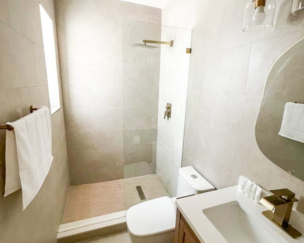 Renovated bathroom with walk-in shower at Tiana Beach Inn in Hollywood Beach Florida