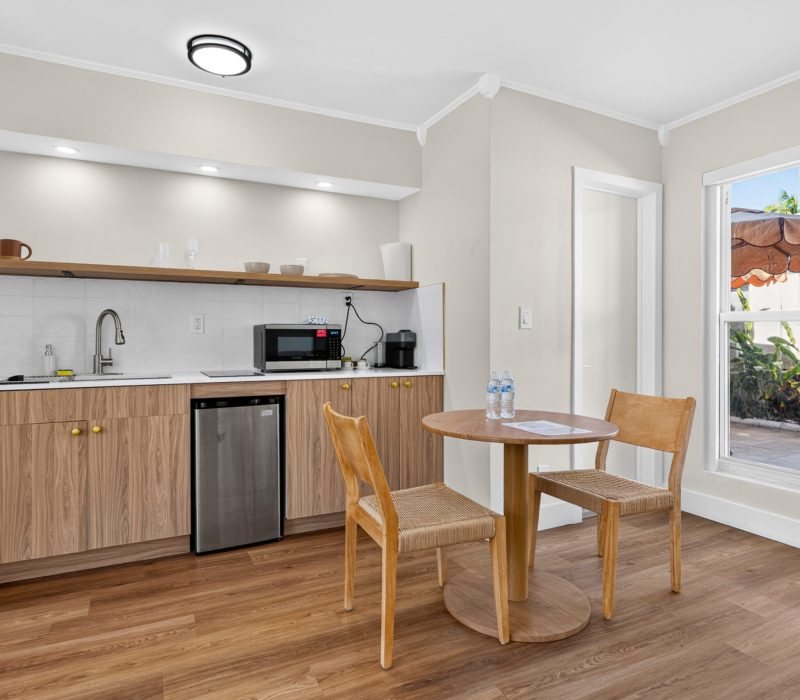Kitchenette and dining table in the Deluxe Quadruple Room at Tiana Beach Inn