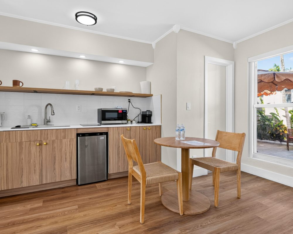 Kitchenette and dining table in the Deluxe Quadruple Room at Tiana Beach Inn