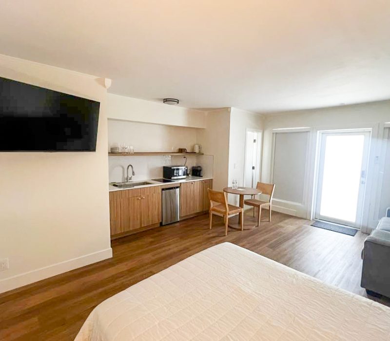 Deluxe hotel room with queen bed, sofa and dining table at Tiana Beach Inn in Hollywood Beach Florida