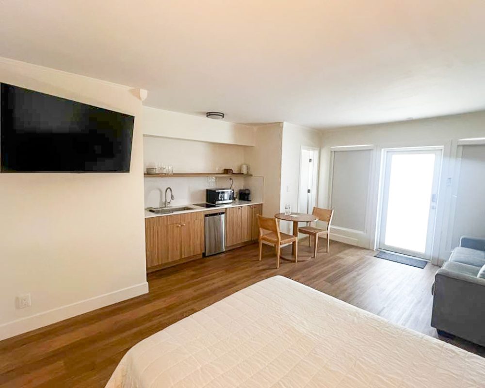 Deluxe hotel room with queen bed, sofa and dining table at Tiana Beach Inn in Hollywood Beach Florida