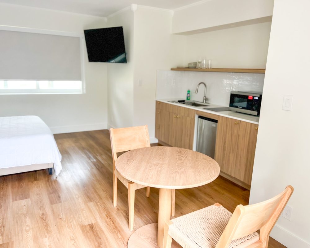 Modern Deluxe Room at Tiana Beach Inn with bed, sofa and private kitchenette near the beach