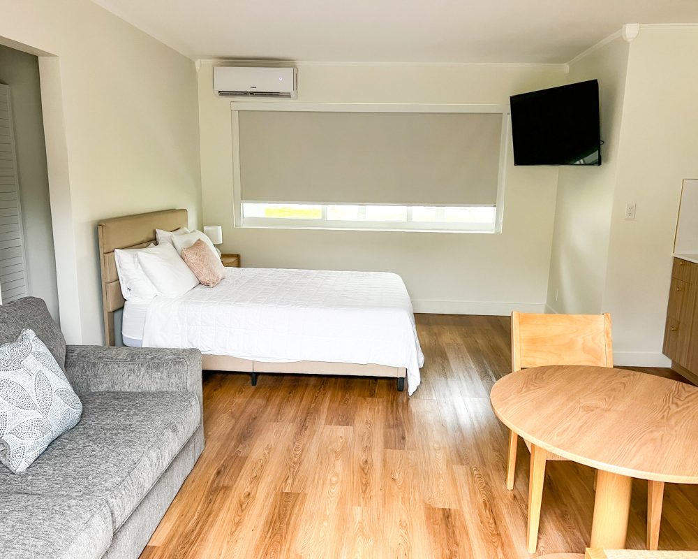 Deluxe Room at Tiana Beach Inn with queen bed, sofa, kitchenette and modern interior in Hollywood Beach Florida