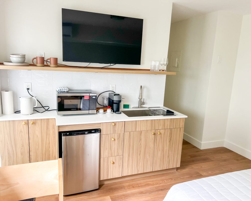 Bright Standard Room with kitchenette and modern furnishings at Tiana Beach Inn near the beach